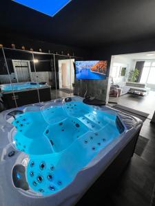 a jacuzzi tub in a room with a tv at Platin City Apartment in Hamburg