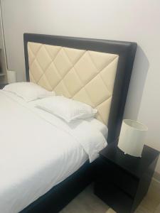 a bed with a black frame and white sheets and pillows at Apartamento remodelado no Seixal in Seixal