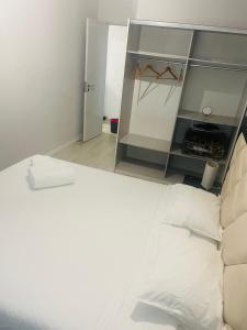 um quarto com uma cama branca e um closet em Apartamento remodelado no Seixal no Seixal
