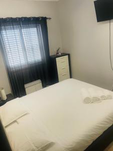 ein Schlafzimmer mit einem großen weißen Bett und einem Fenster in der Unterkunft Apartamento remodelado no Seixal in Seixal
