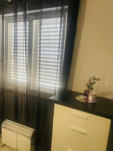uma janela com cortinas pretas e um radiador num quarto em Apartamento remodelado no Seixal no Seixal
