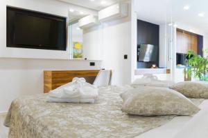 a bedroom with three beds with pillows and a flat screen tv at Apartments Bikin in Brela