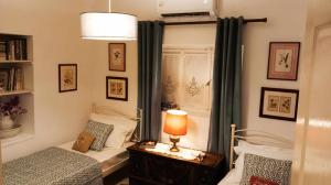 ein Schlafzimmer mit zwei Betten und einem Tisch mit Lampe in der Unterkunft CORALLI in Spetses