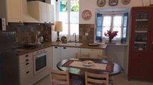 eine Küche mit einem Tisch und einem kleinen Tisch mit Stühlen in der Unterkunft CORALLI in Spetses