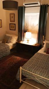 a bedroom with two beds and a window with a lamp at CORALLI in Spetses