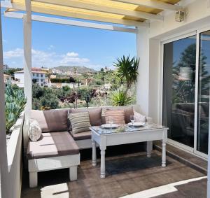 een woonkamer met een bank en een tafel op een balkon bij La Casita en Benajarafe in Málaga