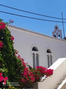 a white church with pink flowers in front of it at CORALLI in Spetses