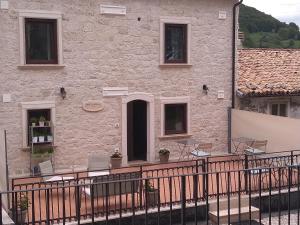 a building with a balcony with chairs and a table at Casa di Carmine 1915 - Solo Adulti in Gamberale