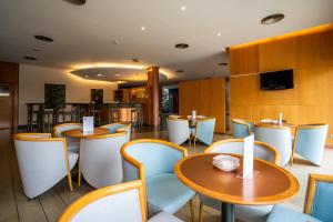 a restaurant with tables and chairs and a television at Posadas De España Paterna in Paterna