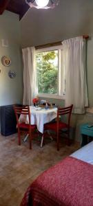 1 dormitorio con mesa, 2 sillas y ventana en Cabaña Liebe Inge en San Carlos de Bariloche