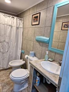 y baño con aseo, lavabo y espejo. en Cabaña Liebe Inge en San Carlos de Bariloche