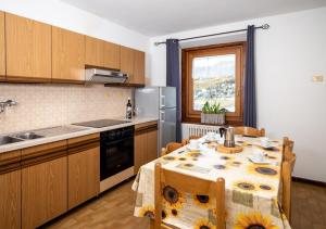 a kitchen with a table with sunflowers on it at Appartamenti Astra in Livigno