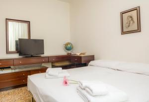 una camera con 2 letti, una TV e uno specchio di Appartamento Mary Few Minutes From Lake - Happy.Rentals a Riva del Garda
