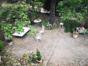 patio ze stołem, krzesłami i doniczkami w obiekcie La bergerie w mieście La Garde-Freinet