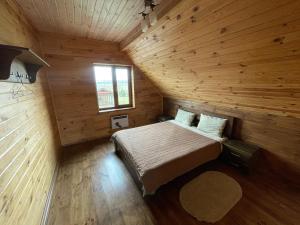 ein Schlafzimmer mit einem Bett in einem Holzzimmer in der Unterkunft 4REST 