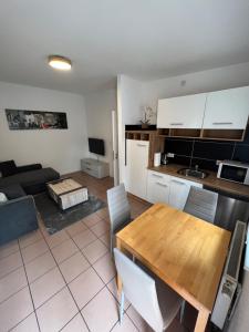 cocina y sala de estar con mesa de madera en Alex Apartments, en Solingen