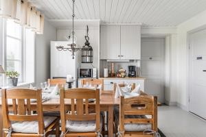 kuchnia i jadalnia z drewnianym stołem i krzesłami w obiekcie STUBBET - Charming - Newly Remade Villa w mieście Vadstena