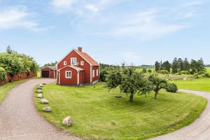 a red house on a field with a gravel road at STUBBET - Charming - Newly Remade Villa in Vadstena