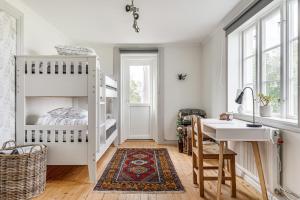 ein weißes Schlafzimmer mit einem Etagenbett und einem Schreibtisch in der Unterkunft STUBBET - Charming - Newly Remade Villa in Vadstena