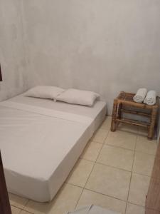 um quarto com uma cama e uma mesa lateral em Hendi Homestay em Gili Gede