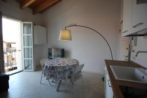 una cocina con una mesa con sillas y una lámpara en Ginny House en Toscolano Maderno