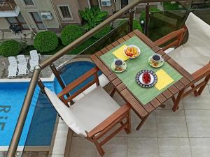 uma mesa e cadeiras com um prato de comida em Голям апартамент с прекрасна гледка кьм морето em Ravda