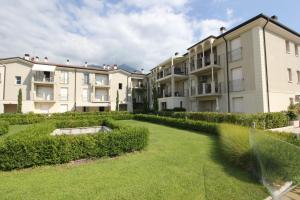 una fila de edificios de apartamentos con un patio verde en Ginny House en Toscolano Maderno