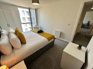 a bedroom with a large bed with a large window at Cosy 2 Bed Apt Sleeps 4+Balcony in Manchester