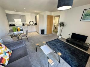 a living room with a couch and a table at Cosy 2 Bed Apt Sleeps 4+Balcony in Manchester