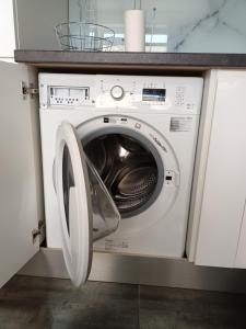 - un lave-linge blanc avec une porte ouverte dans la cuisine dans l'établissement Apartment, à Tallinn