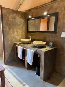 Windhoek Game Camp في Lafrenz Township: حمام مغسلتين ومرآة