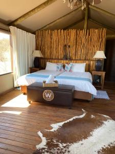 Windhoek Game Camp في Lafrenz Township: غرفة نوم بسرير كبير وطاولة