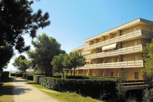 a large apartment building with trees in front of it at Bibione Beach Apartments in Bibione