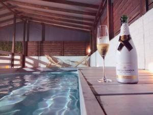 a bottle of champagne and a glass next to a swimming pool at Suite dreams in Netiv HaShayyara