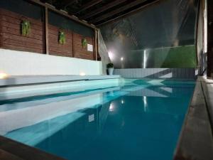 a swimming pool with blue water in a building at Suite dreams in Netiv HaShayyara