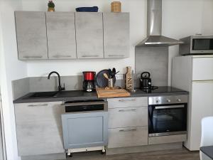 a kitchen with a sink and a stove top oven at L'hippocampe in Gruissan +17 photos