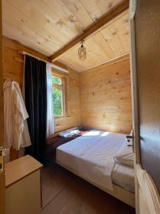 una camera con un letto in una cabina di legno di Hotel Voisa/სასტუმრო ვოისა a Batumi