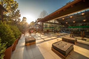 a patio with tables and trunks on top of a building at Hotel Laghetto Gramado in Gramado