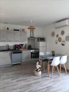 a kitchen with a table and chairs in a room at L'hippocampe in Gruissan