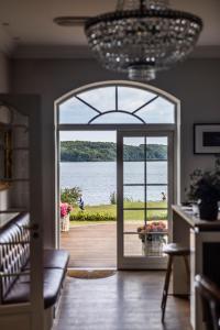 una camera con una porta che si apre su una vista sull'acqua di Stella Maris a Svendborg