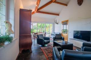 een woonkamer met een bank en stoelen en een tv bij Countryside - experience in Koewacht