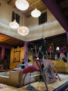 a room with a pink flamingo chair and lights at Riad Hotel Les Flamants in Merzouga
