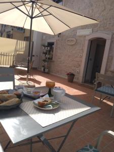 una mesa con un plato de comida y una sombrilla en Casa di Carmine 1915 - Solo Adulti, en Gamberale