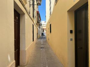 an empty alleyway between two buildings in a city at Aljara Corredera in Córdoba
