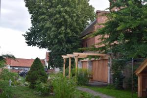 a garden in front of a house with a tree at Apartment 1 im Martinsgarten Angermünde in Angermünde