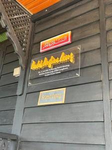 a wooden wall with signs on the side of a building at Pondok Panglima Awang in Pantai Cenang
