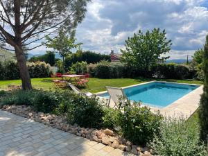 a swimming pool in a yard with two chairs and a table at Suite 671 in Reyrieux