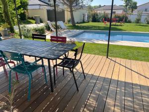a table and chairs on a deck next to a pool at Suite 671 in Reyrieux