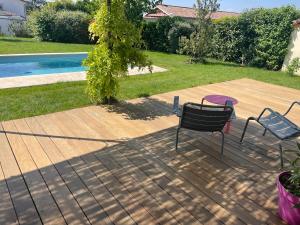 two chairs and a table on a deck next to a pool at Suite 671 in Reyrieux