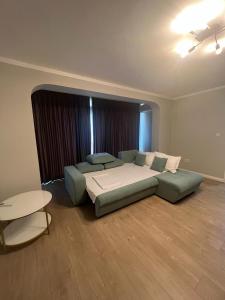um quarto com uma cama, um sofá e uma mesa em Apart Central em Orşova